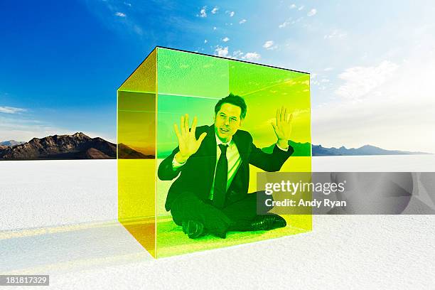 man in box on salt flats, hands on glass. - glass box stock pictures, royalty-free photos & images