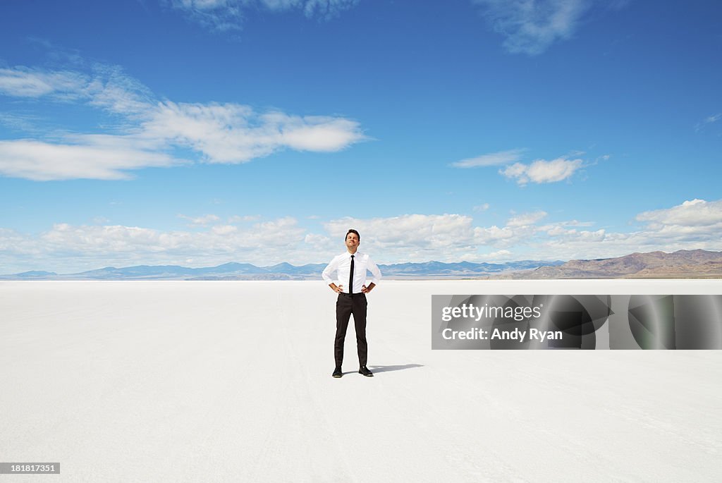 Man alone in salt flats, looking up smiling.