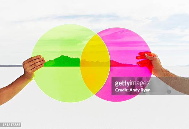two hands holding colored circles in landscape. - transparent concept stock pictures, royalty-free photos & images