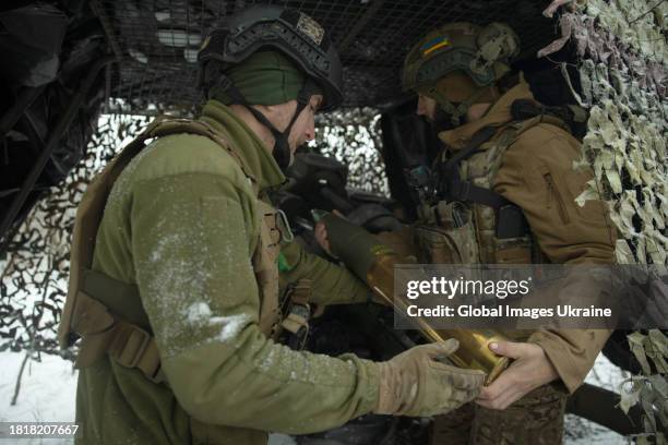 Crewmembers of the 105-mm British howitzer L119 loads a projectile into the howitzer for firing onto Russian positions near the occupied Ukrainian...