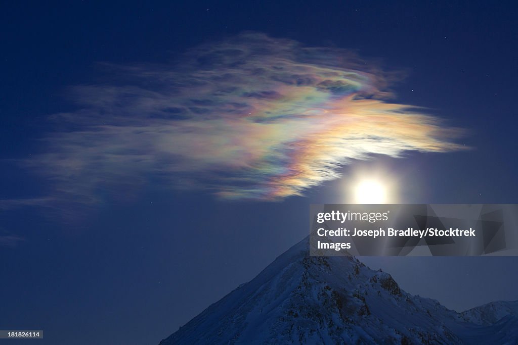 Full moon with rainbow clouds over Ogilvie Mountains, Tombstone Park, Dempster Highway, Canada.