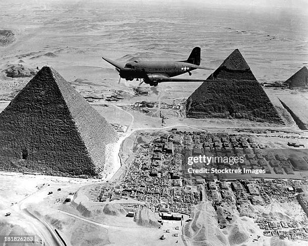 an air transport command plane flies over the pyramids in egypt. - 1943 stock pictures, royalty-free photos & images