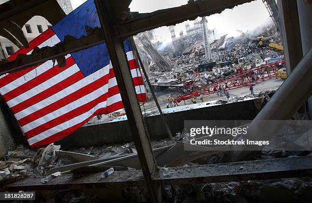 the american flag is prominent amongst the rubble of what was once the world trade center. - 911 photos et images de collection