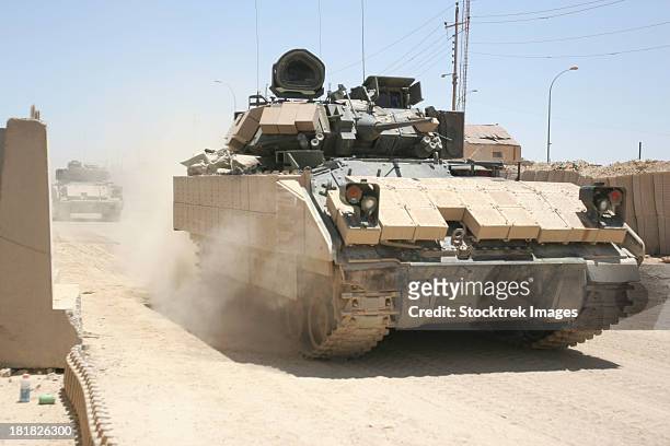 june 6, 2006 - u.s. soldiers in an m2 bradley fighting vehicle patrol past command post hit, near hit, iraq. - armored personnel carrier stock pictures, royalty-free photos & images