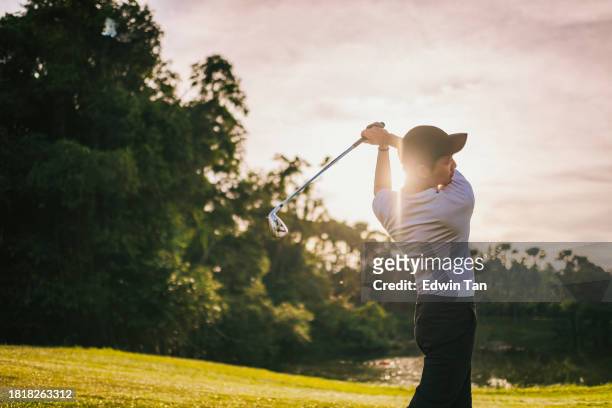 asian chinese golfer teeing off in golf course weekend morning - golfer swing stock pictures, royalty-free photos & images