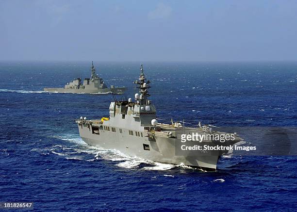 jds hyuga sails in formation with u.s. navy and japan maritime self defense force ships. - japanse maritieme zelfverdedigingskrachten stockfoto's en -beelden