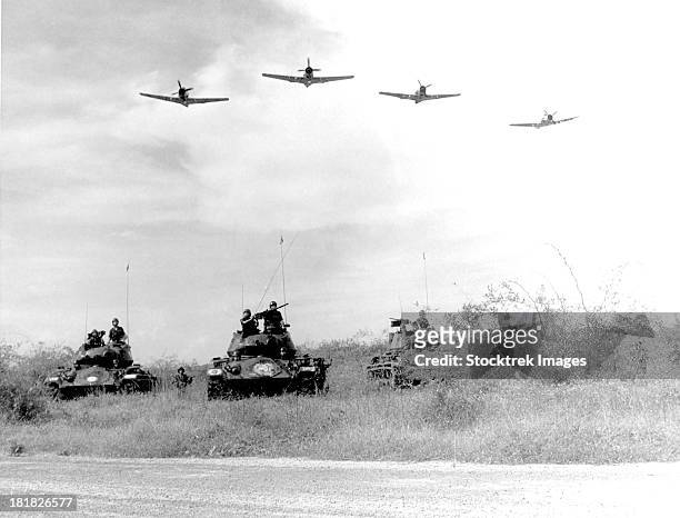 a-1h aircraft make a low level pass over vietnamese tanks and ground troops. - vietnam war stock pictures, royalty-free photos & images