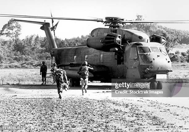 soldiers run to a hh-53c helicopter during an asualt on koh tang island. - helicopter photos imagens e fotografias de stock