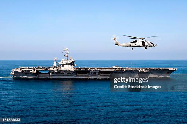 an mh-60r sea hawk flies near the nimitz-class aircraft carrier uss john c. stennis. - operation enduring freedom stock pictures, royalty-free photos & images