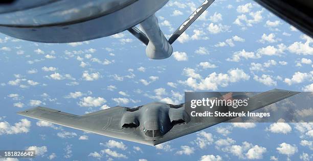 a b-2 spirit approaches the refueling boom of a kc-135 stratotanker. - list stock-fotos und bilder