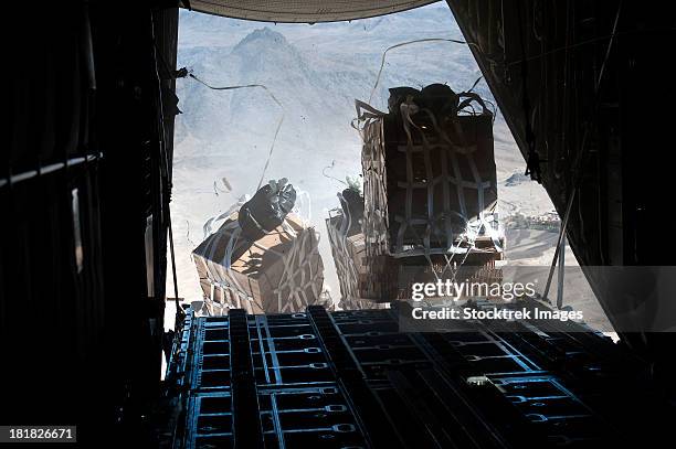 pallets are released from a c-130 hercules over afghanistan. - military afghanistan stock pictures, royalty-free photos & images