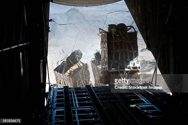 pallets are released from a c-130 hercules over afghanistan. - military operations in afghanistan imagens e fotografias de stock