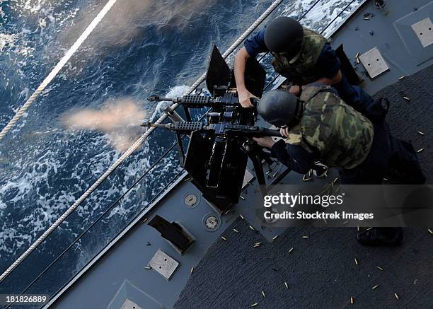 gulf of aden, january 24, 2012 - sailors fire a dual-mounted m240 machine gun during a live-fire exercise aboard the guided-missile cruiser uss bunker hill. - gulf of aden stock pictures, royalty-free photos & images