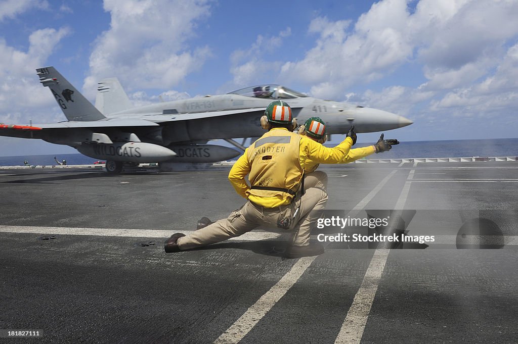 Shooters give the signal to launch an F/A-18C Hornet.