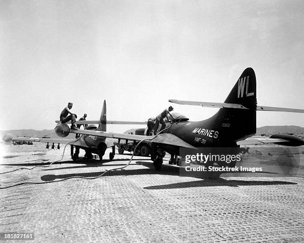 the f9f panther jets are refueling after rockets have been hung under the wings. ca. 1951. - 1951 stock pictures, royalty-free photos & images