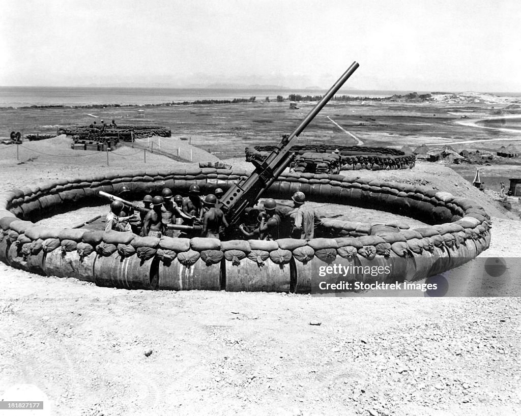 July 18, 1945 - View of a 90mm AAA gun emplacement with crew in pit, Okinawa, Japan.