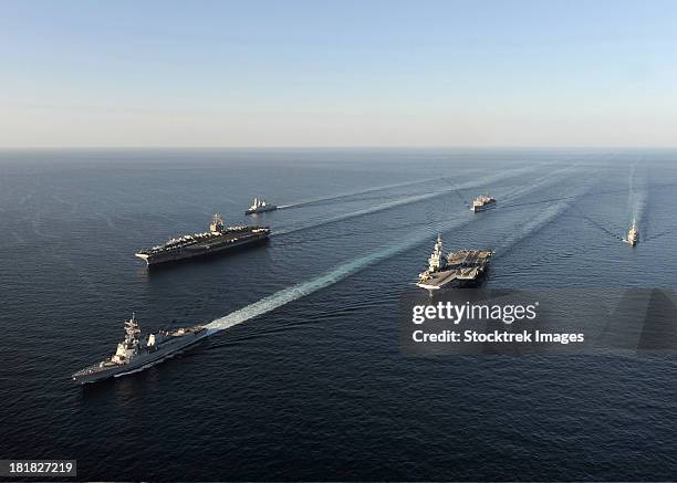 fleet of navy ships transit the arabian sea. - porte avion charles de gaulle photos et images de collection