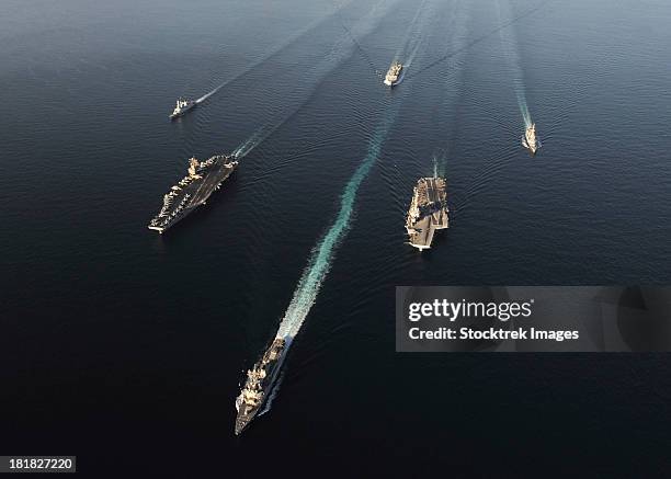 fleet of navy ships transit the arabian sea. - porte avion charles de gaulle photos et images de collection