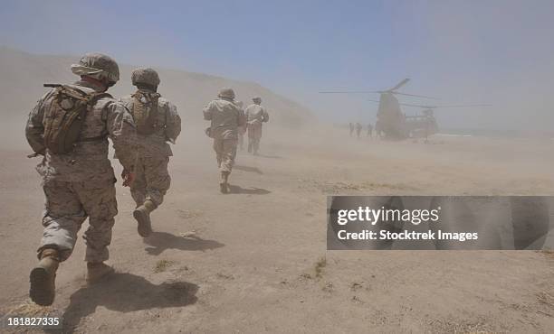 marines move through a dust cloud toward a ch-46 sea knight. - american soldier stock-fotos und bilder