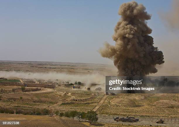 a cloud of dust and debris rises into the air in afghanistan. - afghanistan war stock pictures, royalty-free photos & images