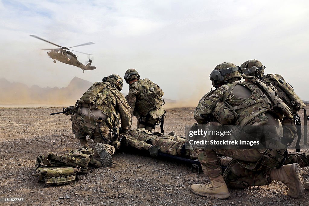 Security force team members wait for a UH-60 Blackhawk medevac helicopter.
