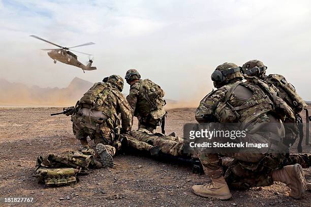 security force team members wait for a uh-60 blackhawk medevac helicopter. - military operations in afghanistan imagens e fotografias de stock