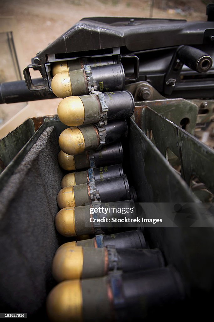 Linked 40mm rounds feed into a Mark 19 grenade launcher.