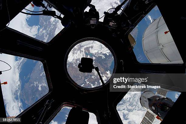 view of earth through the cupola on the international space station. - estação espacial internacional - fotografias e filmes do acervo