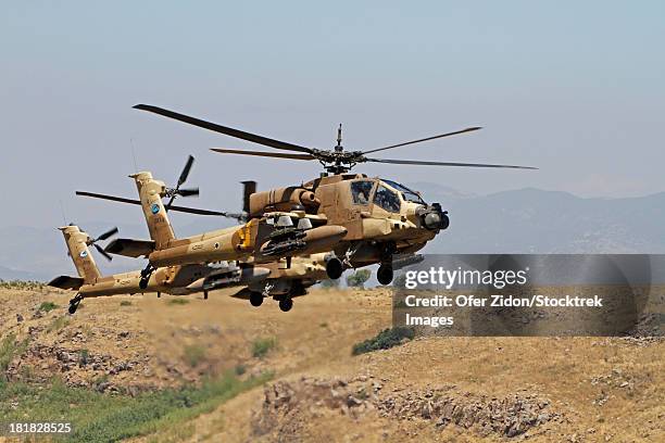 two ah-64a peten attack helicopters of the israeli air force in flight over the golan heights, israel. - elicottero militare foto e immagini stock