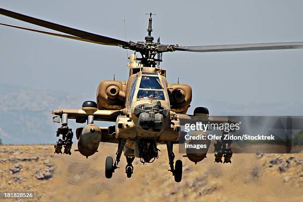 an ah-64a peten attack helicopter of the israeli air force display its hellfire missiles during flight over the golan heights, israel. - apache helikopter stockfoto's en -beelden