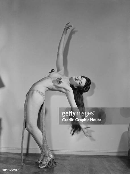 Burlesque performer bending over backwards in a two-piece stage costume, circa 1945.