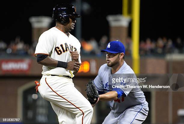 Tony Abreu of the San Francisco Giants gets caught in a rundown between third base and home, and gets tagged out by pitcher Ricky Nolasco of the Los...