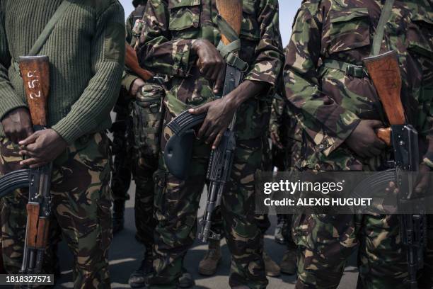 Kenyan soldiers from the East African Community regional force hold AK assault rifles as they prepare to leave the Democratic Republic of Congo at...