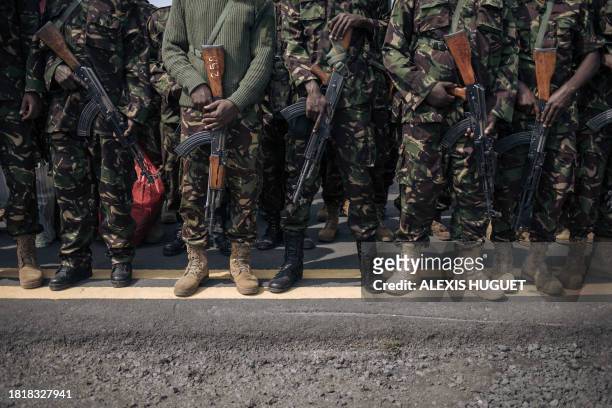 Kenyan soldiers from the East African Community regional force hold AK assault rifles as they prepare to leave the Democratic Republic of Congo at...