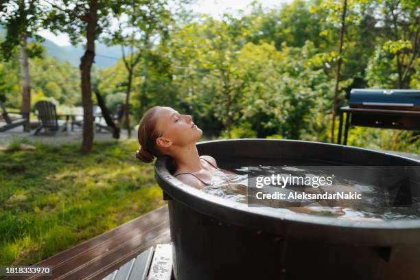 young woman taking an ice bath - cryotherapy stockfoto's en -beelden