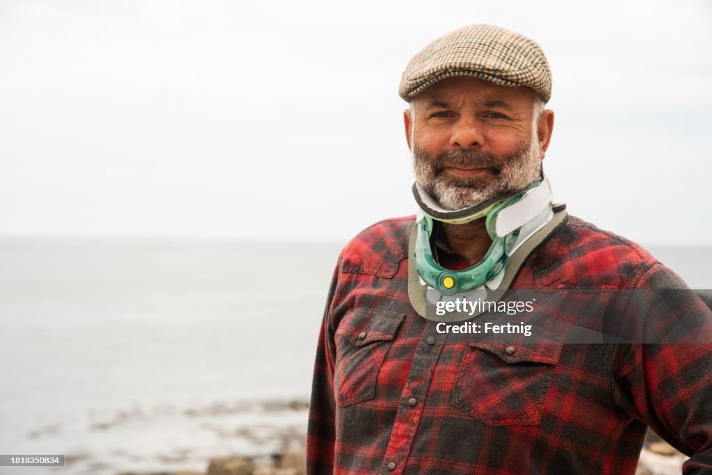 A mature man wearing an orthopedic neck brace after cervical stenosis surgery.