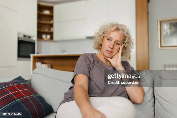 winter wellness: senior woman's comfort - mid adult women stock pictures, royalty-free photos & images