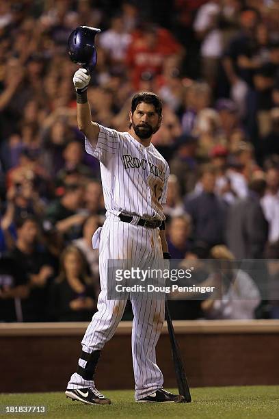 Todd Helton of the Colorado Rockies tips his hat to the standing ovation of fans as he prepares to take an at bat against the Boston Red Sox during...