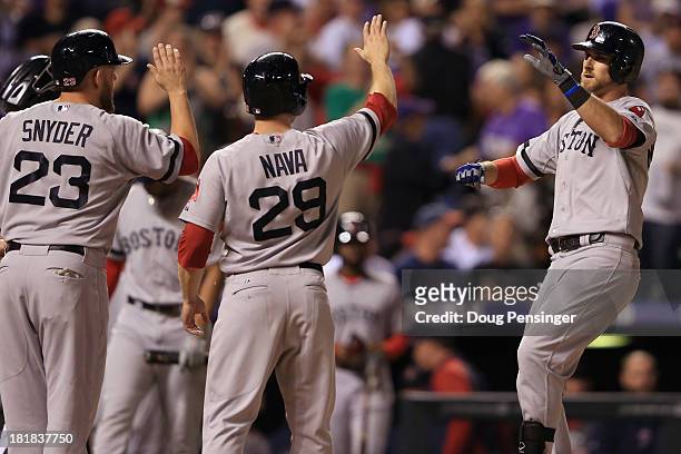Will Middlebrooks of the Boston Red Sox celebrates his grand slam off of Roy Oswalt of the Colorado Rockies with Daniel Nava and Brandon Snyder of...