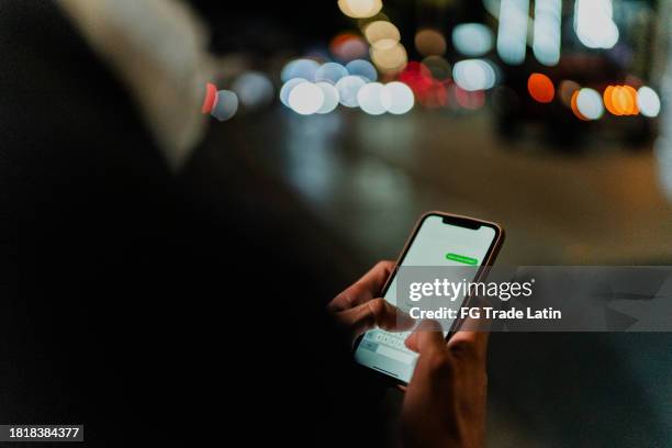 close-up of a man typing on mobile phone outdoors - snapchat stock pictures, royalty-free photos & images