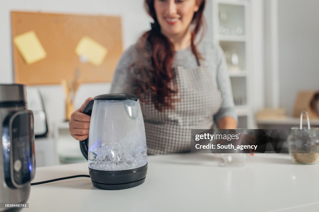 Hispanic woman boiling water in the kettle