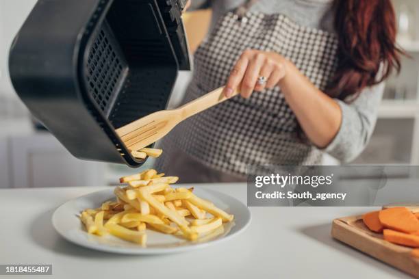 hispanic woman making french fries in the air fryer - airfryer stock pictures, royalty-free photos & images