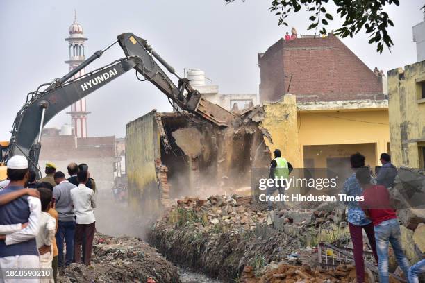 Bulldozer of Nagar Panchayat Dasna removes illegal encroachment on the pond built in Dasna, on December 2 , 2023 in Ghaziabad , India.