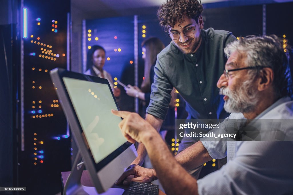 Engineers using computer in server room