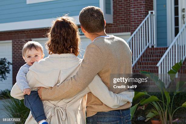 young family looking at house - family standing stock pictures, royalty-free photos & images