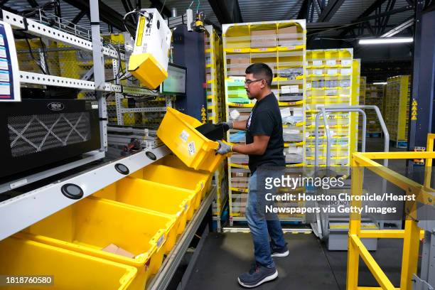 Jiovanni Martinez places an item in a crate to be sent on to be boxed for shipping at the Amazon HOU6 Fulfillment Center on Monday, Nov. 27, 2023 in...