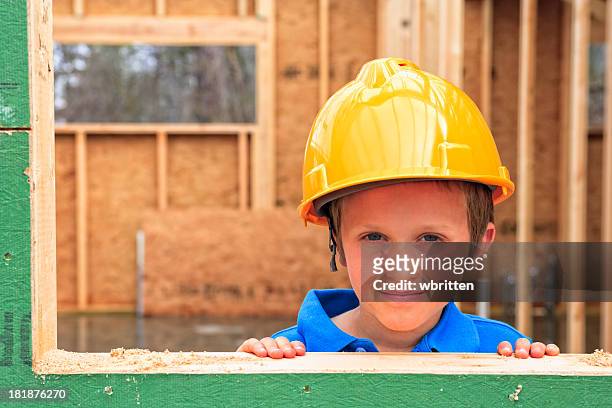 enfant avec chapeau dur sur chantier de construction - boy in hard hat photos et images de collection