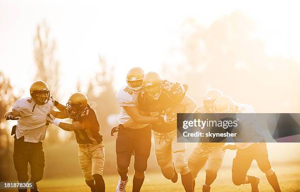 college football - catch and tackle. - college football player stock pictures, royalty-free photos & images