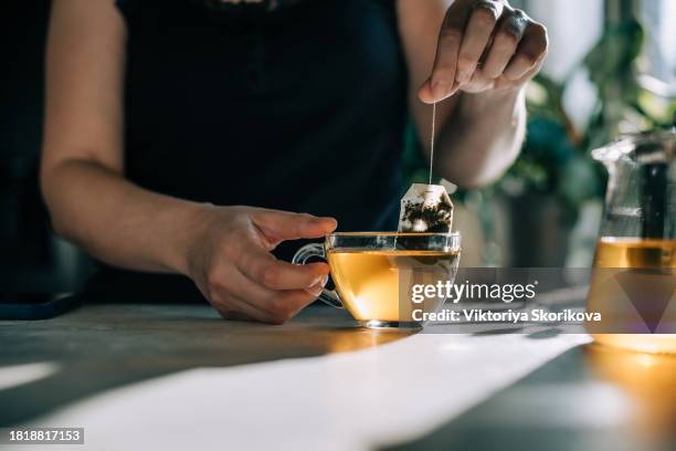 woman taking tea bag out of cup at table indoors, closeup - red saucer stock pictures, royalty-free photos & images