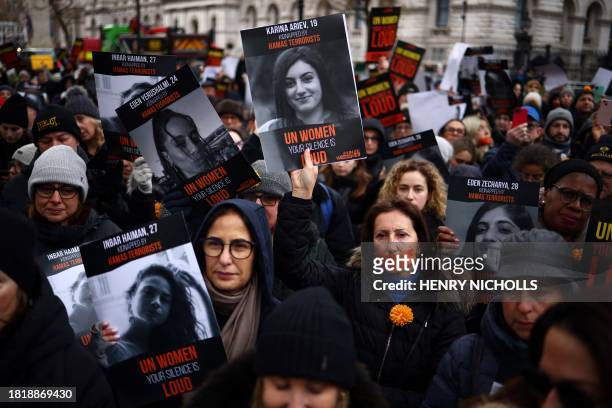 Demonstrators hold posters of women being held hostage in Gaza during a rally in London on December 3, 2023 to protest against what they consider a...